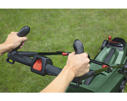 Osoba obsluhuje kosačku na trávu