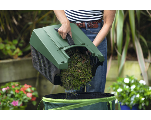 Osoba vyprázdňuje trávu a lístie zametacím strojom do záhradného vreca