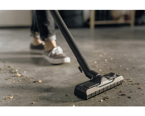 Vysávač v prevádzke na podlahe so špinou