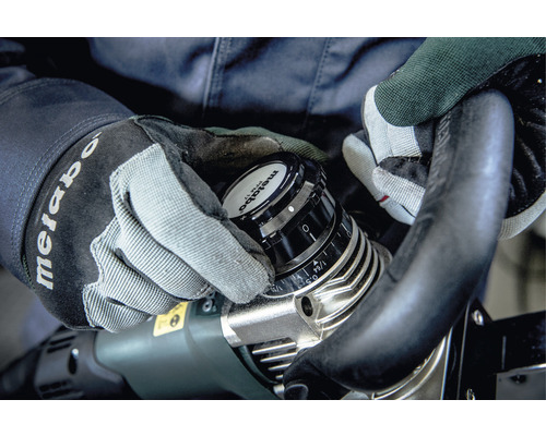 Osoba nastavuje frézku Metabo s rukavicami