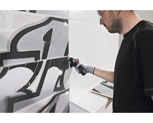 Obkladač reže dlaždicu uhlovou brúskou