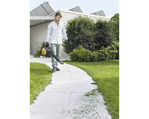 Muž čistí chodník pomocou fúkača lístia