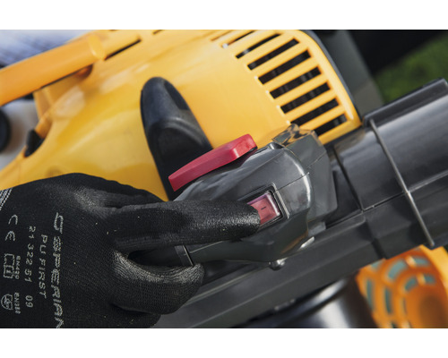 Detailný záber žltého vysávača lístia s rukou na spínači