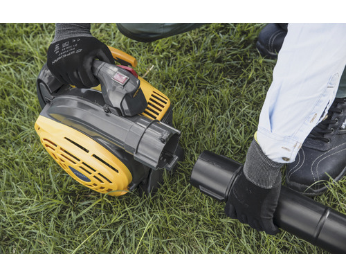 Žltý vysávač lístia sa montuje na trávnik.