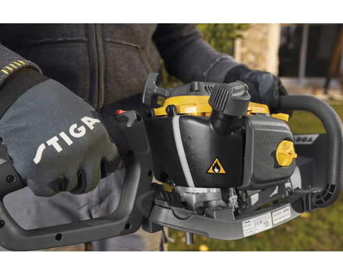 Detailný záber osoby s rukavicami Stiga držiacej nožnice na živý plot.