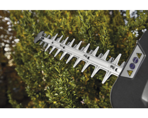 Rezacie zariadenie nožníc na živý plot v prevádzke pred živým plotom.