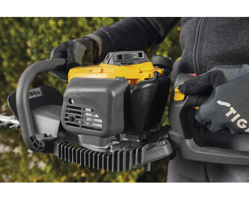 Osoba drží žlté a sivé nožnice na živý plot