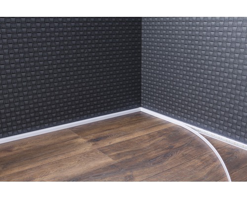 Roh miestnosti s tmavým obkladom stien, laminátovou podlahou a bielymi podlahovými lištami