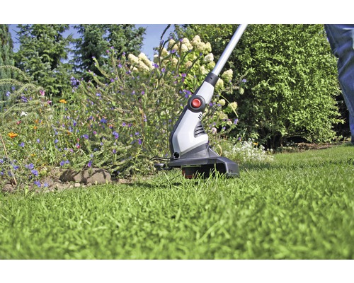 Zastrihávač trávnika v prevádzke v záhrade