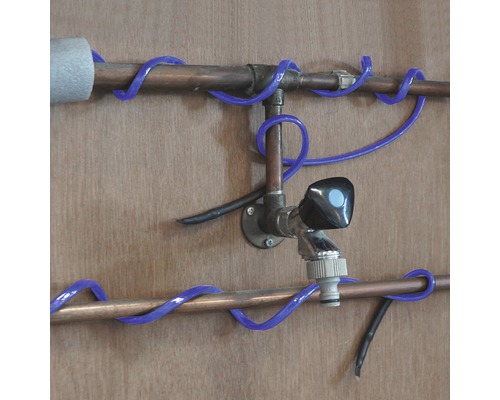 Inštalácia medených rúrok s vodovodným kohútikom a modrým vykurovacím káblom potrubia.