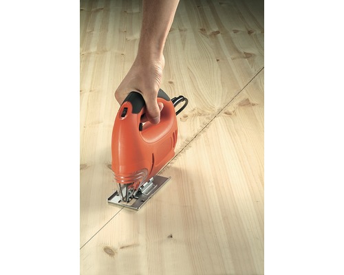 Osoba reže drevenú dosku pozdĺž čiary pomocou priamočiarej píly.