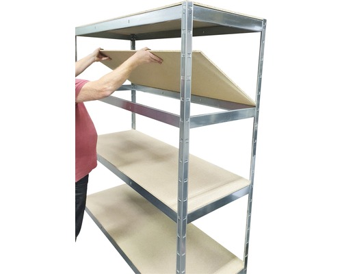 Osoba vkladá policu do kovového regálu.