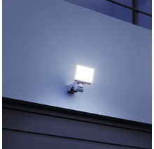 Štvorcový LED vonkajší reflektor namontovaný na stene.