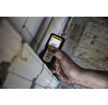 Ruka s laserovým diaľkomerom Stabila meria stenu