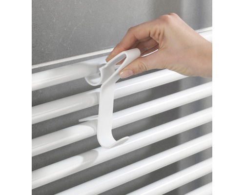 Ruka zavesuje háčik na radiátor na radiátor