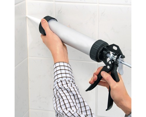 Nanášanie tmelu pomocou aplikačnej pištole na dlaždice