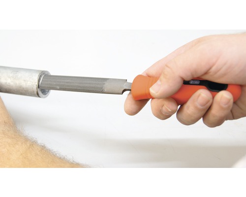 Ruka používa pilník na kľúče na odstraňovanie otrepov na rúre.