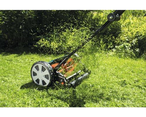 Ručná kosačka na trávu pri kosení trávnika v záhrade