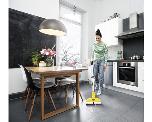 Žena upratuje kuchyňu elektrickým mopom