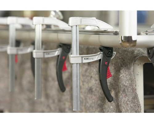 Niekoľko rýchloupínacích svoriek KliKlamp pripevnených k rúrke.