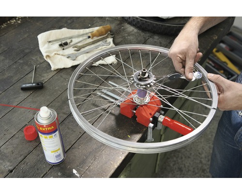 Oprava bicykla s náradím, ráfikom a drôtmi