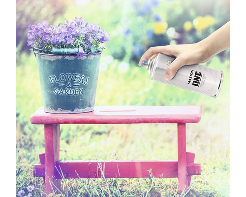 Scéna s kvetmi v zinkovom vedre na stoličke, ktorá je striekaná sprejom s farbou.