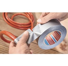 Osoba opravuje hadicu lepiacou páskou. Logo Tesa.