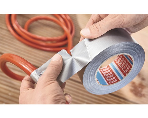 Osoba opravuje hadicu lepiacou páskou. Logo Tesa.