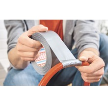 Osoba opravuje hadicu lepiacou páskou