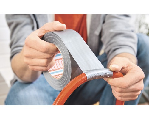 Osoba opravuje hadicu lepiacou páskou