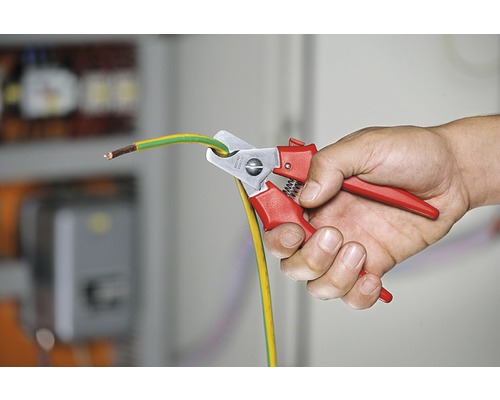 Osoba strihá uzemňovací kábel pomocou nožníc na káble