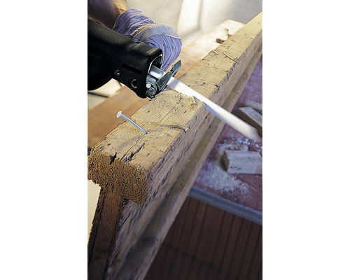 Priamočiara píla reže drevenú dosku s klincami.