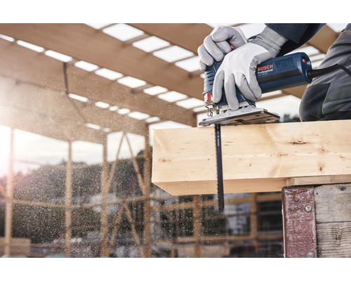 Remeselník reže drevo priamočiarou pílou Bosch.