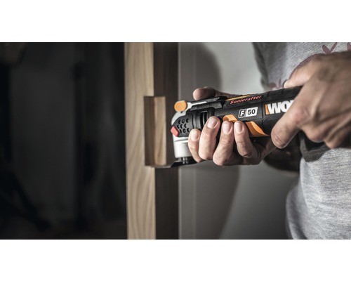 Muž používa multifunkčnú brúsku Worx na spracovanie dreva.