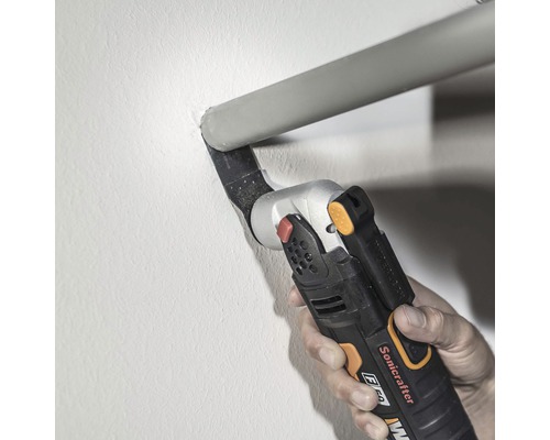 Ruka ovláda multifunkčnú rezačku na rezanie rúrky na stene.