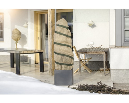 Terasa s ochrannými vakmi na rastliny a záhradnými stolmi v zime.