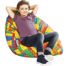 Chlapec sedí v sedacom vaku s dizajnom stavebných blokov.