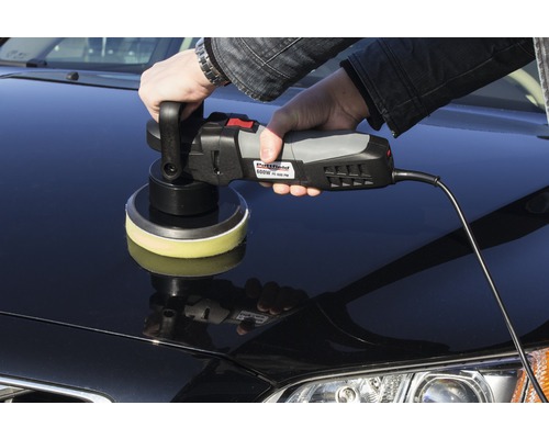 Osoba leští auto pomocou leštičky.