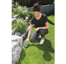 Žena používa nožnice na trávu v záhrade na údržbu trávnika.