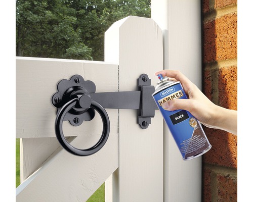 Na záhradnú bránku sa nanáša sprejová farba