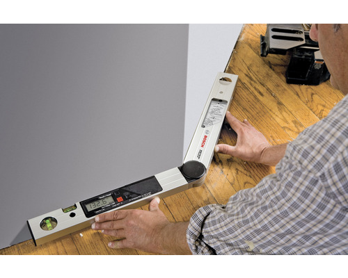 Digitálny uhlomer pri používaní, na meranie uhla na stene.