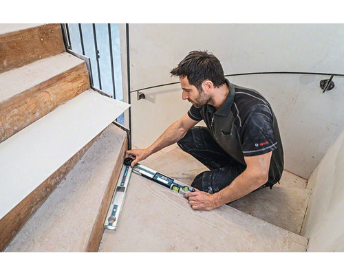 Remeselník meria schody uhlomerom