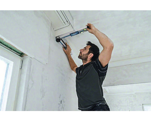 Muž používa vodováhu na renováciu interiéru.