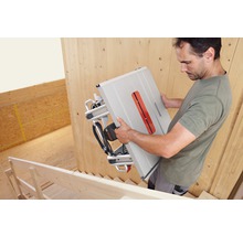 Muž nesie stolnú okružnú pílu Bosch po schodoch.