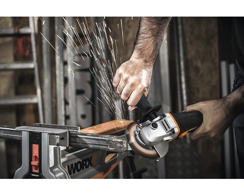 Muž brúsi kov uhlovou brúskou, pričom vznikajú iskry.