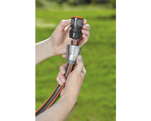 Dve ruky spájajú záhradnú hadicu so spojkou.