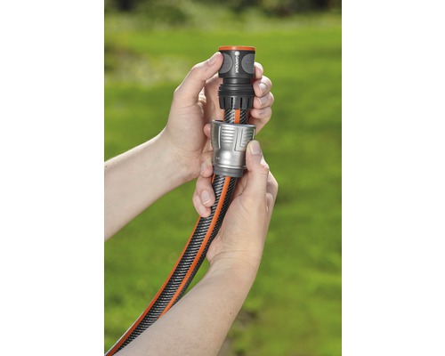 Dve ruky spájajú záhradnú hadicu s konektorom hadice.