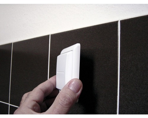 Kolískový spínač je namontovaný pred tmavé dlaždice.