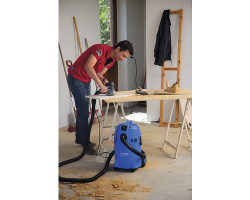 "Muž brúsi drevenú dosku brúskou