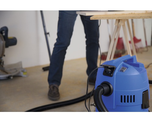 Dielenská scéna s vysávačom, pracovným stolom a remeselníkom